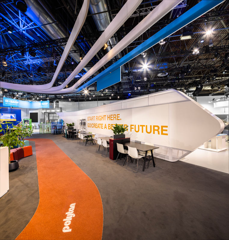 Weitläufiger Messestand für BASF mit weißem und orangefarbenem Design.